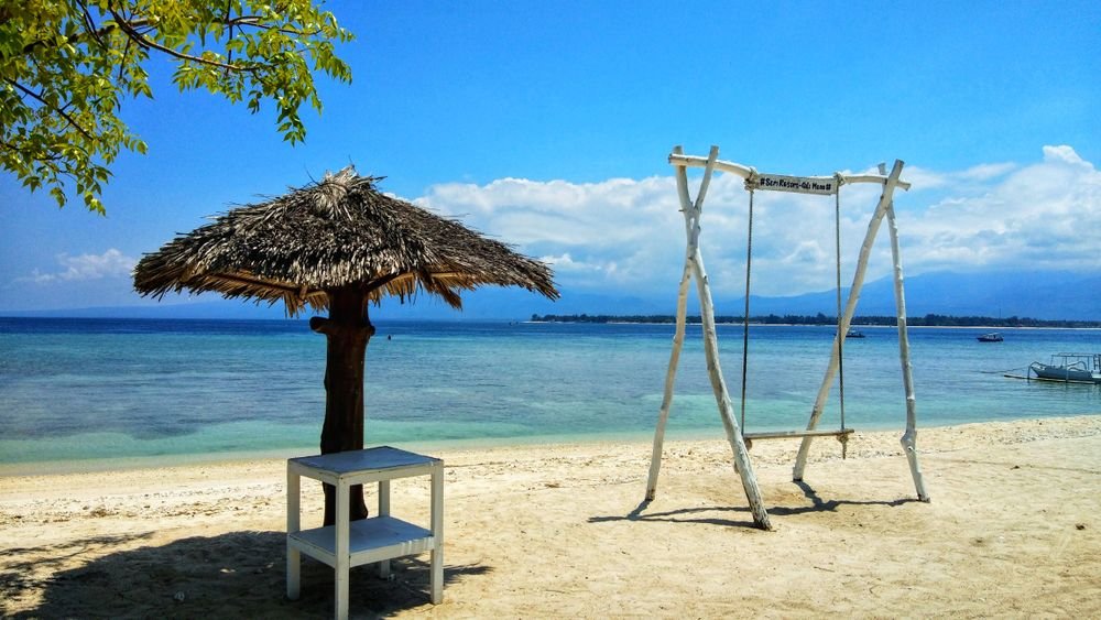 A beach swing by clear water