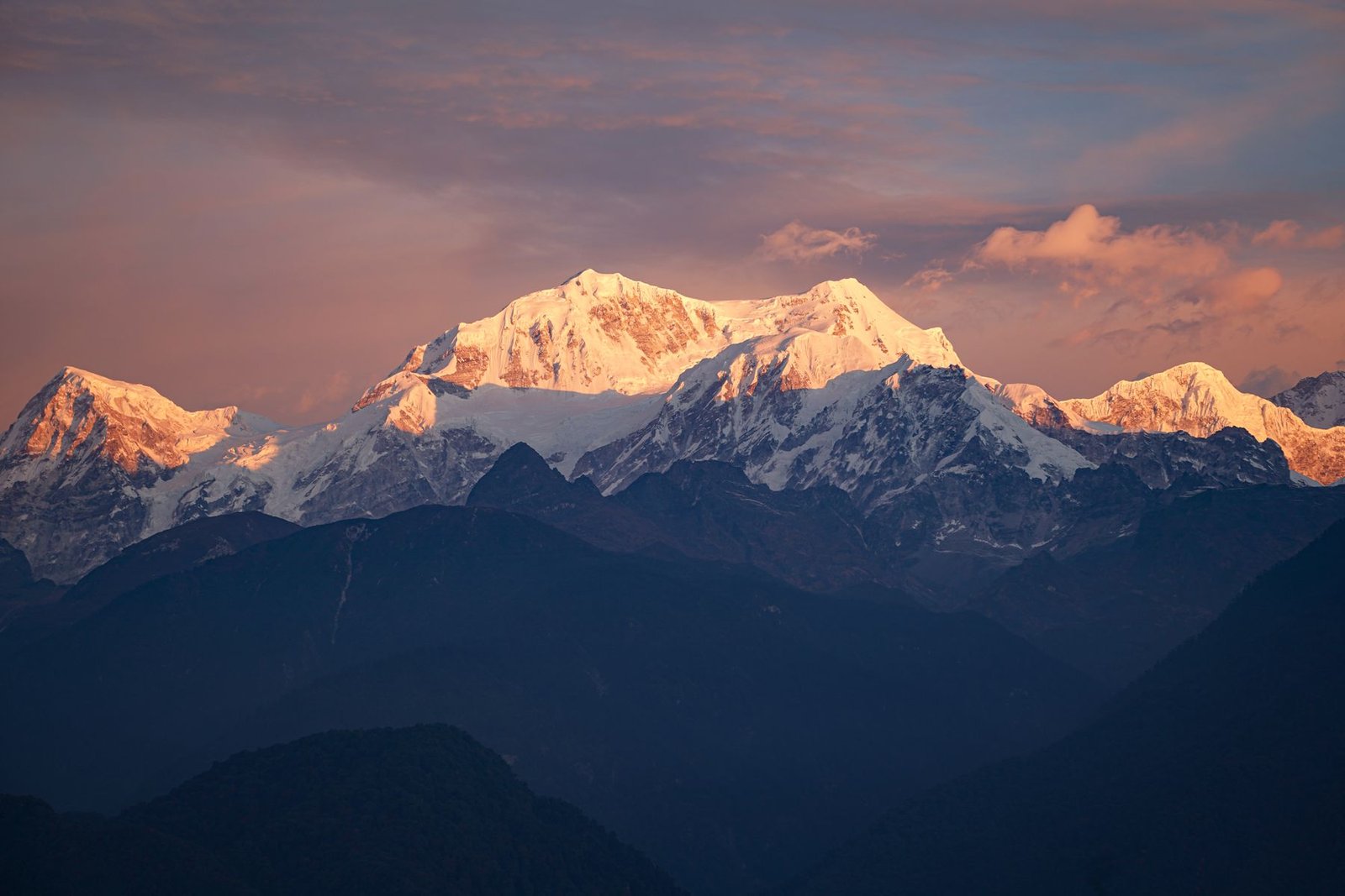 Kanchenjunga glowing at sunrise above the dark ridges of the eastern Himalaya