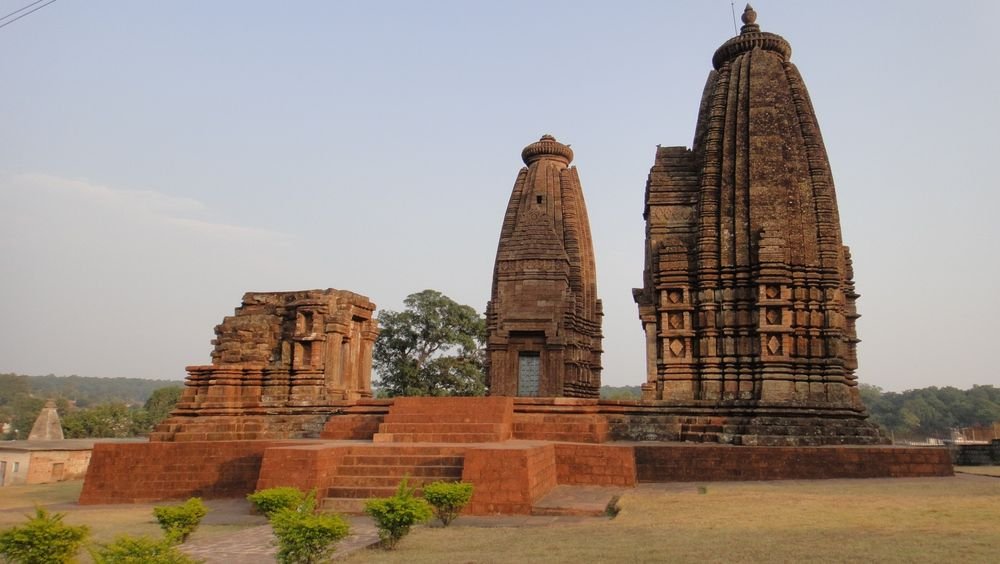 Old stone temples beside a temple tank
