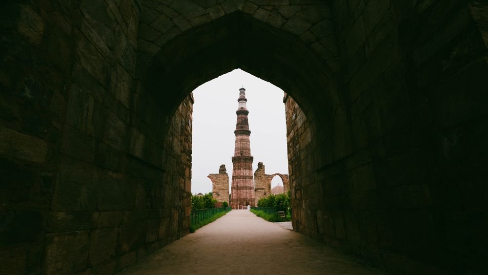 Qutub Minar through a stone archway, Delhi